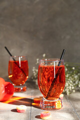 Glass of tasty cocktail with marmalade on tile table, closeup. Valentine's Day celebration