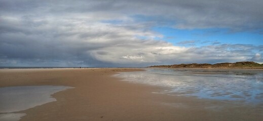 Sandstrand bei Ebbe mit Wolken am Himmel