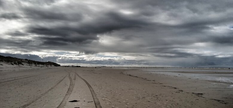 Wolken &uuml;ber dem Strand mit Spuren im Sand