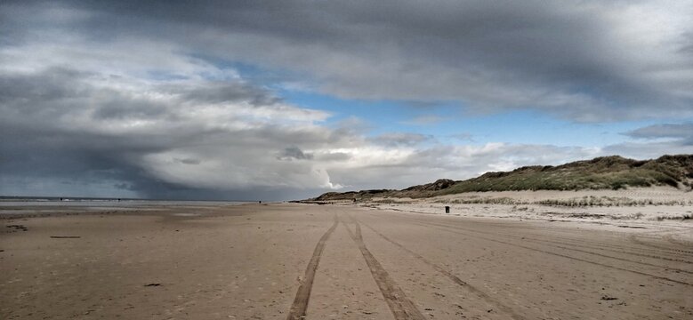 Strand mit Spuren bei nahendem Sturm