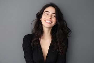 Obraz premium Portrait of a joyful young businesswoman against a gray backdrop