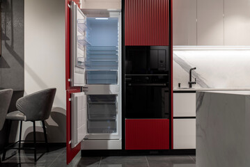 Kitchen featuring built-in appliances, refrigerator, and oven with red decor