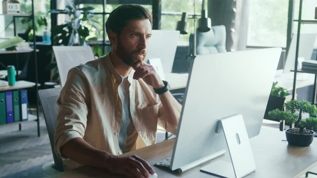 Serious Focused Professional Typing in Modern Sunlit Office