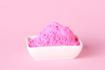 Bowl of powder pigment on pink background
