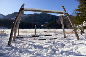 Spielplatz im Winter mit Klettergerüst und Schaukeln