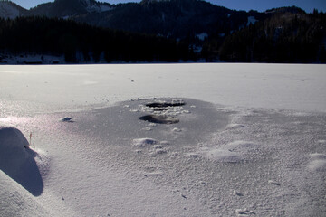 Eisloch in einem See im Winter mit Schnee und EIs        