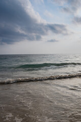 sea horizon with bright sunrise blue sky from sandy beach and rolling waves at morning