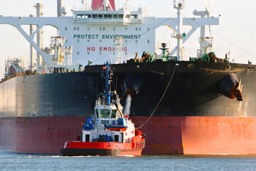 Aerial view of a tugboat and a large oil tanker in the port of Rotterdam