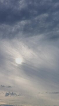 Quality beautiful vertical time lapse of grey sky with sun through clouds