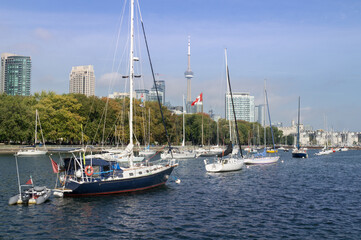 Yachts parked in Toronto waterfront marina in blue waters of lake Ontario with downtown Toronto skyline in background