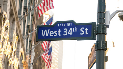 Fototapeta premium West 34th Street Sign in New York City with American Flags