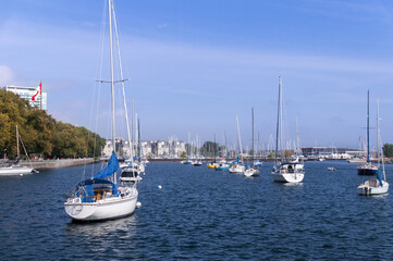 Yachts parked in Toronto waterfront marina in blue waters of lake Ontario with downtown Toronto skyline in background