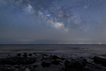 能登半島の海岸の岩場と水平線から望む天の川