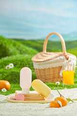 A spring picnic takes place on a green lawn, food and drink scattered arranged on a white picnic carpet with some unbranded sunscreen bottle displayed in center. Background of green hill and blue sky