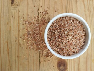 Red rice in bowl on wooden table 
