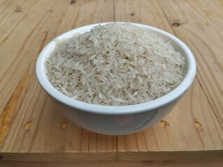 White rice in bowl on wooden table 