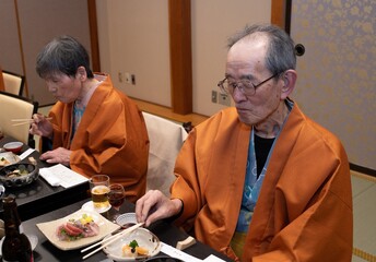 Old Asian couple in yukata kimono having traiditional Japanese meal in Japan