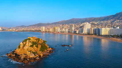 Aerial view of Acapulco Bay in front of the rocky island Farallon del Obispo. Some people swimming...