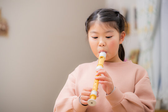 音楽のリコーダー（縦笛）を練習する女の子