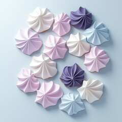 Pastel meringue cookies arranged on light blue background isolated design on white background