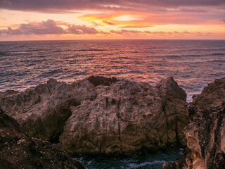 Obraz premium Coastal Sunrise Over Rocks