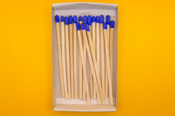 Open matchbox with neatly aligned blue-tipped matches