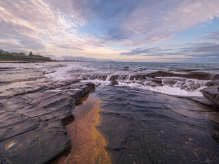 Moody Coastal Morning with Waves Crashing on Rocks
