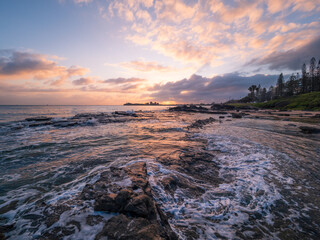 Colourful Coastal Sunrise with Waves on Rocks