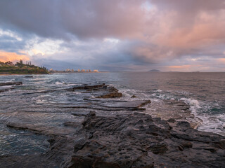 Colourful Coastal Sunrise with Waves on Rocks