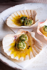 Sea scallops with greens served in a shell in a restaurant