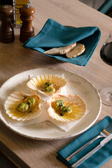 Sea scallops with greens served in a shell in a restaurant