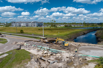 Reconstruction of damaged road bridge destroyed by river after flood water washed away asphalt....