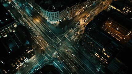 Obraz premium Aerial night view of city intersection with traffic.