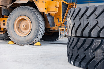 Replacing tires on wheels of mining dump car in garage. Maintenance fix service of industry truck