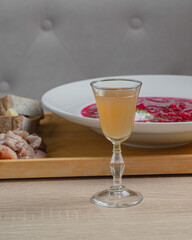 A plate with borscht, bread, garlic and lard stands on a table in a restaurant