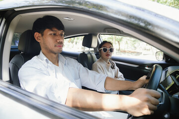 Confident young man in car, smiling while using phone for navigation. This image shows a fun journey, modern lifestyle and the positive energy of travel. Service