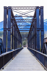A bridge with a wooden walkway and a mountain in the background