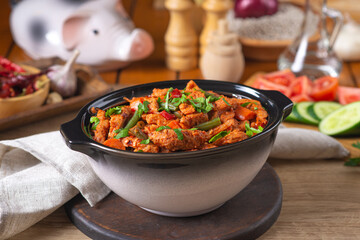 Baked meat in tomato sauce with herbs in a ceramic dish.