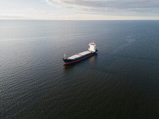 Cargo ship sailing in the Gulf of Finland (Baltic Sea) at sunset. Drone point of view.
