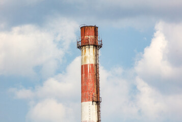 A tall, rusted, red and white tower with a ladder on it