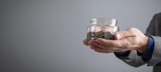 Man showing jar of coins. Business