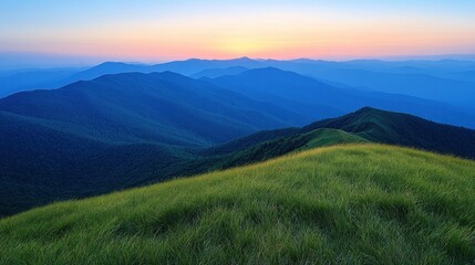 Naklejka premium Sunset over rolling blue mountains, grassy peak.