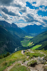 Fototapeta premium Wanderin mit Rucksack blickt von der 