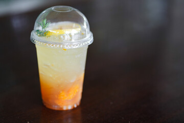 iced cool yuzu espresso, yuzu orange syrup flavor mixed with honey topped on wooden table in copy space concept.