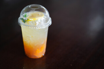 iced cool yuzu espresso, yuzu orange syrup flavor mixed with honey topped on wooden table in copy space concept.