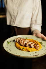 A waiter serving a dish.
