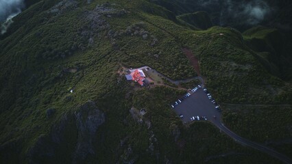Aerial View of Hilltop Building Surrounded by Green Vegetation and Parking Area
