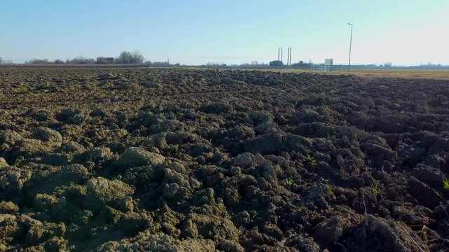 I fly the drone low over a dark plowed land that has not yet been cultivated

