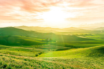beautiful green valley with green fields with green spring grass with nive hills and mountains and...