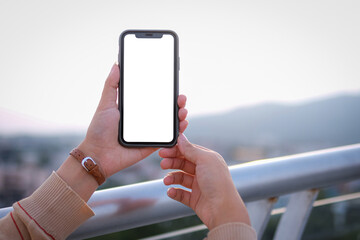 Woman holding a mobile phone to take pictures of cityscapes